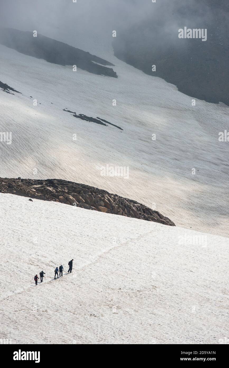 Russia, Kamchatka, vulcano Mutnovsky, turisti che attraversano un campo di neve Foto Stock