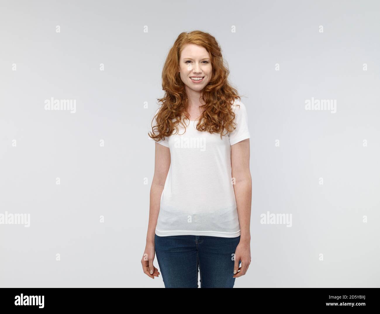 Ritratto di sorridente giovane donna di fronte a uno sfondo bianco Foto Stock