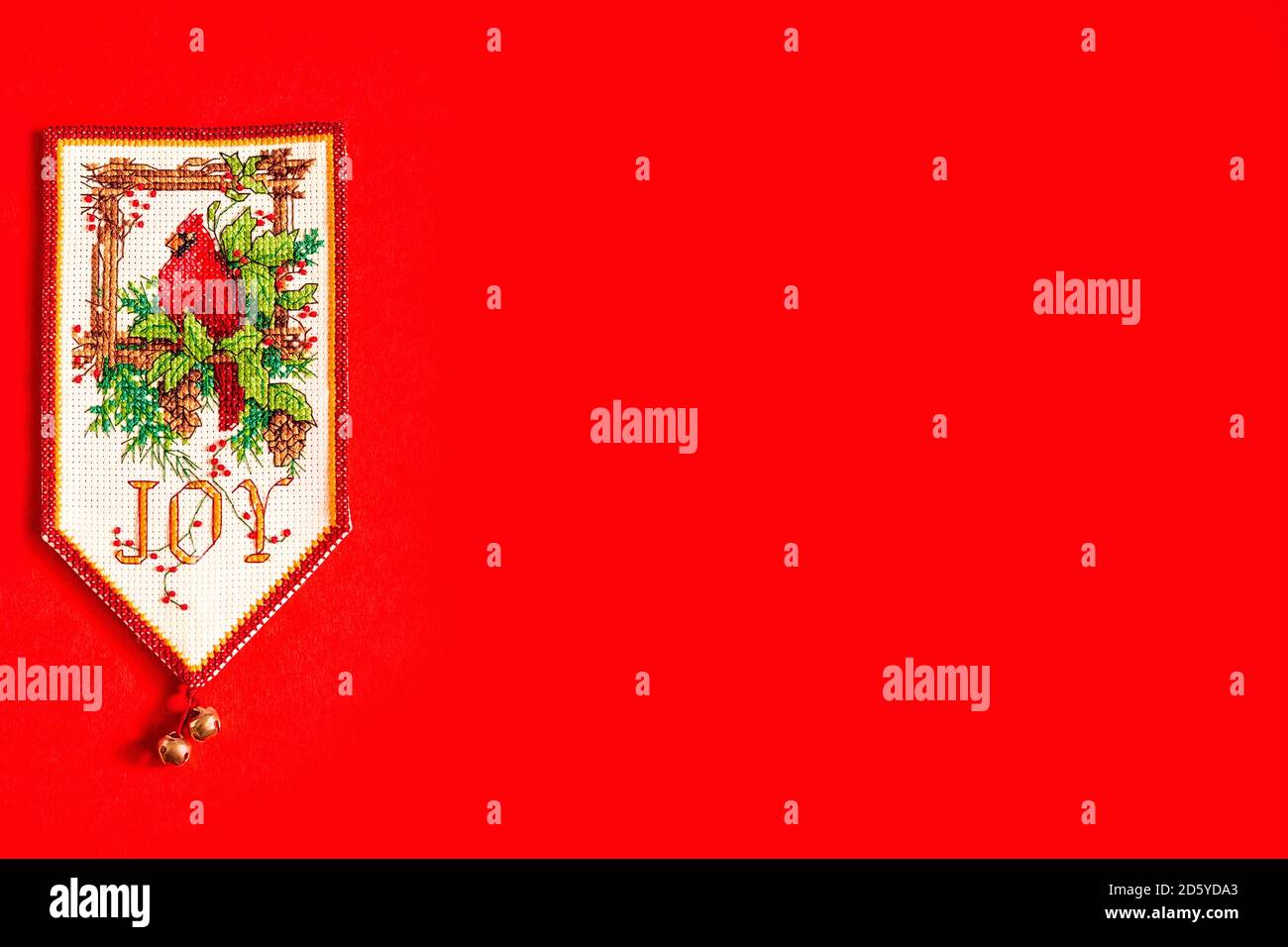 Sfondo natalizio con bandiera ricamata di nuovo anno su sfondo rosso, vacanza, nuovo anno e concetto di Natale. Vacanza. Uccello di Natale su un pino Foto Stock