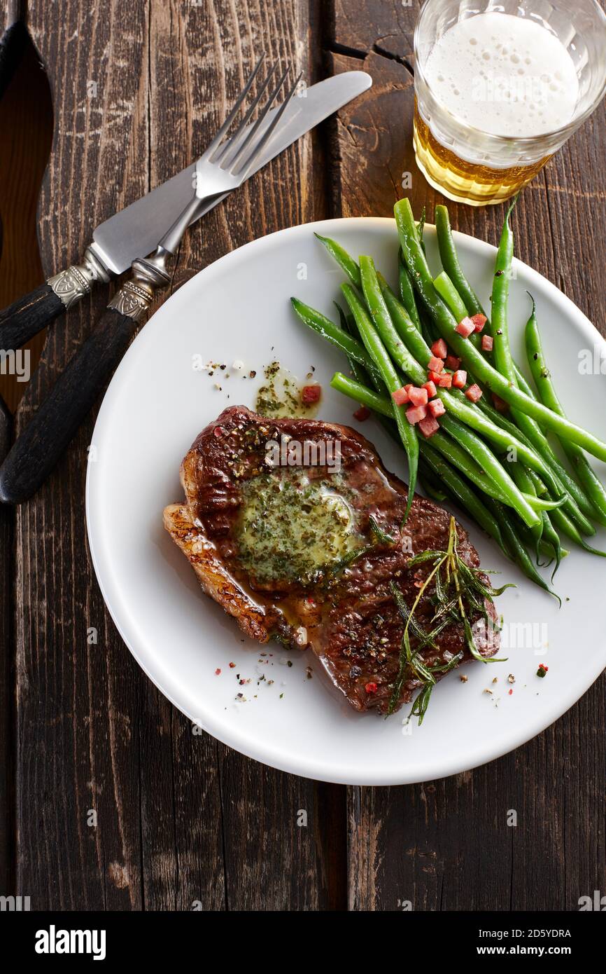 Scamone bistecca con burro erborinati, fagiolini e pancetta Foto Stock