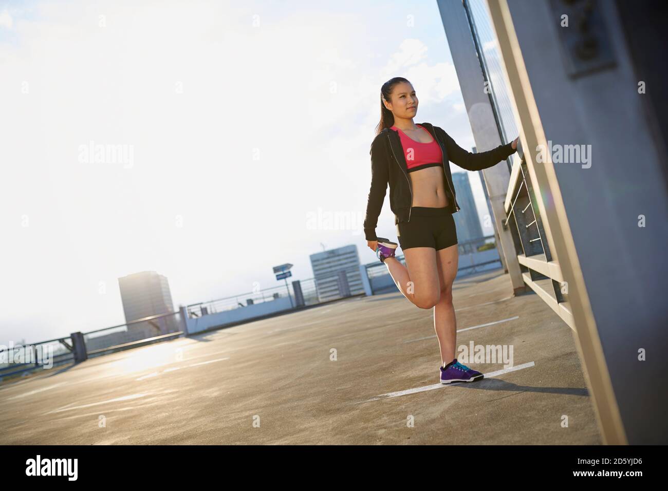 Giovani femmine Asian sportive facendo esercizi di stretching Foto Stock