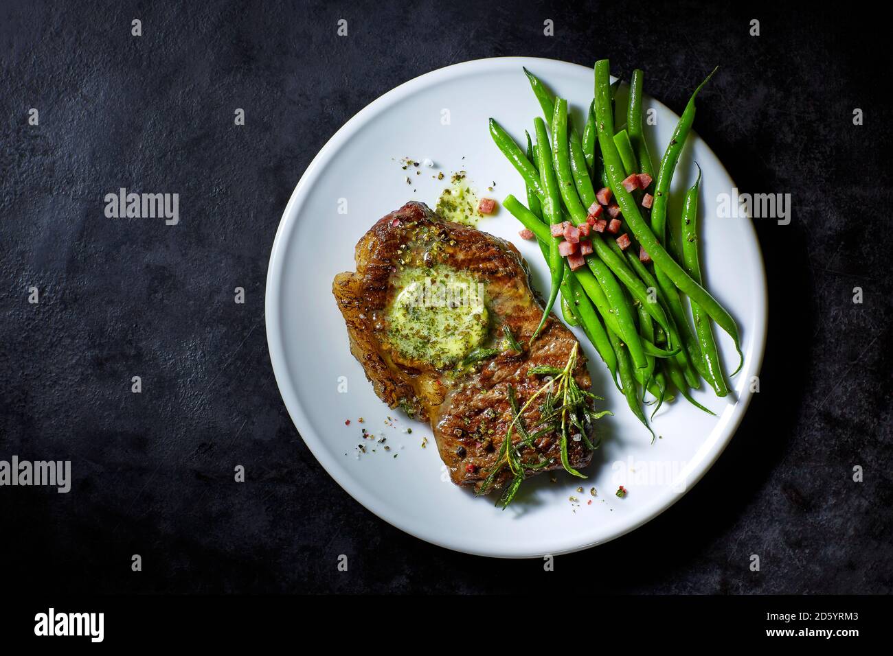 Scamone bistecca con burro erborinati, fagiolini e pancetta Foto Stock