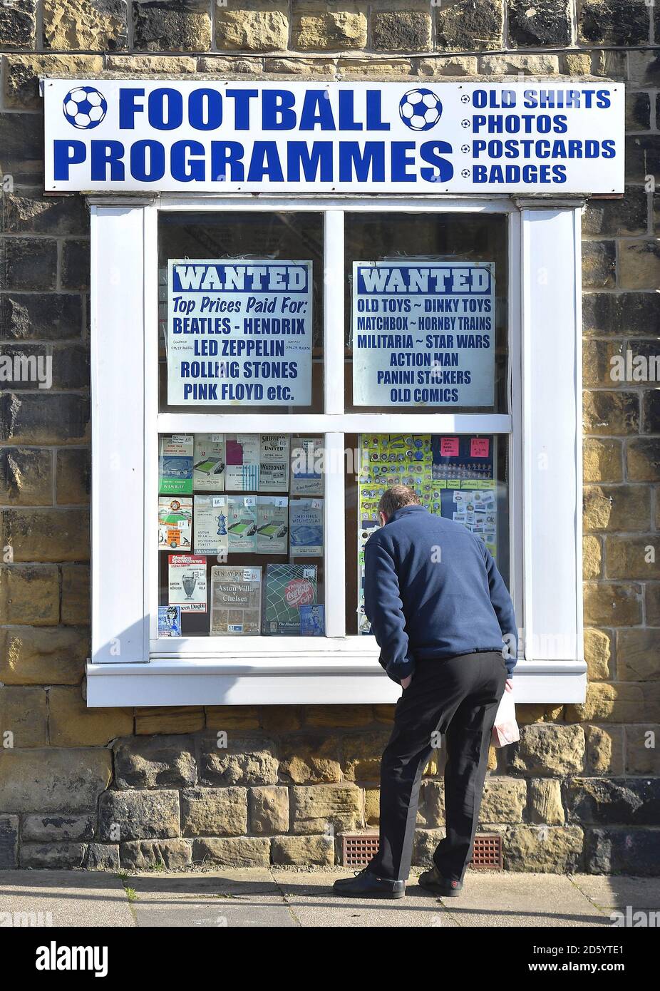 Un fan guarda i vecchi programmi prima del gioco Foto Stock