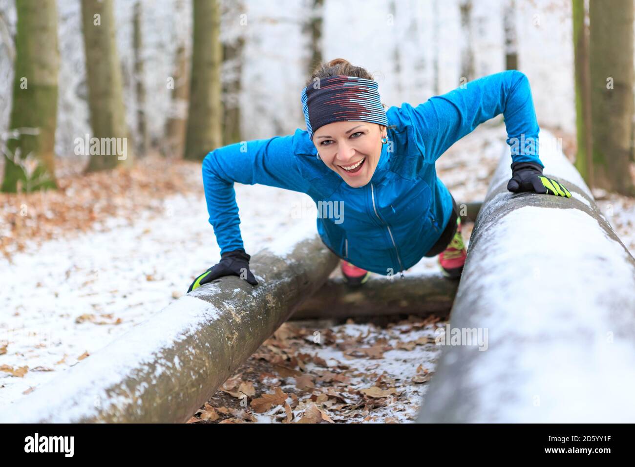 Allenamento donna su percorso fitness nella foresta invernale Foto Stock