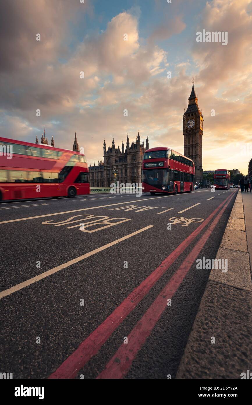 UK, Londra, autobus rossi passando Westminster Bridge con il Big Ben tower in background al tramonto Foto Stock