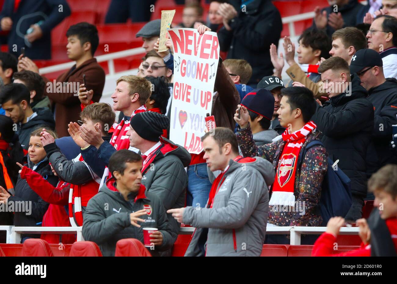Tifosi in stand con un cartello che indica 'mai goona Give you up' a sostegno dell'Arsenal Foto Stock