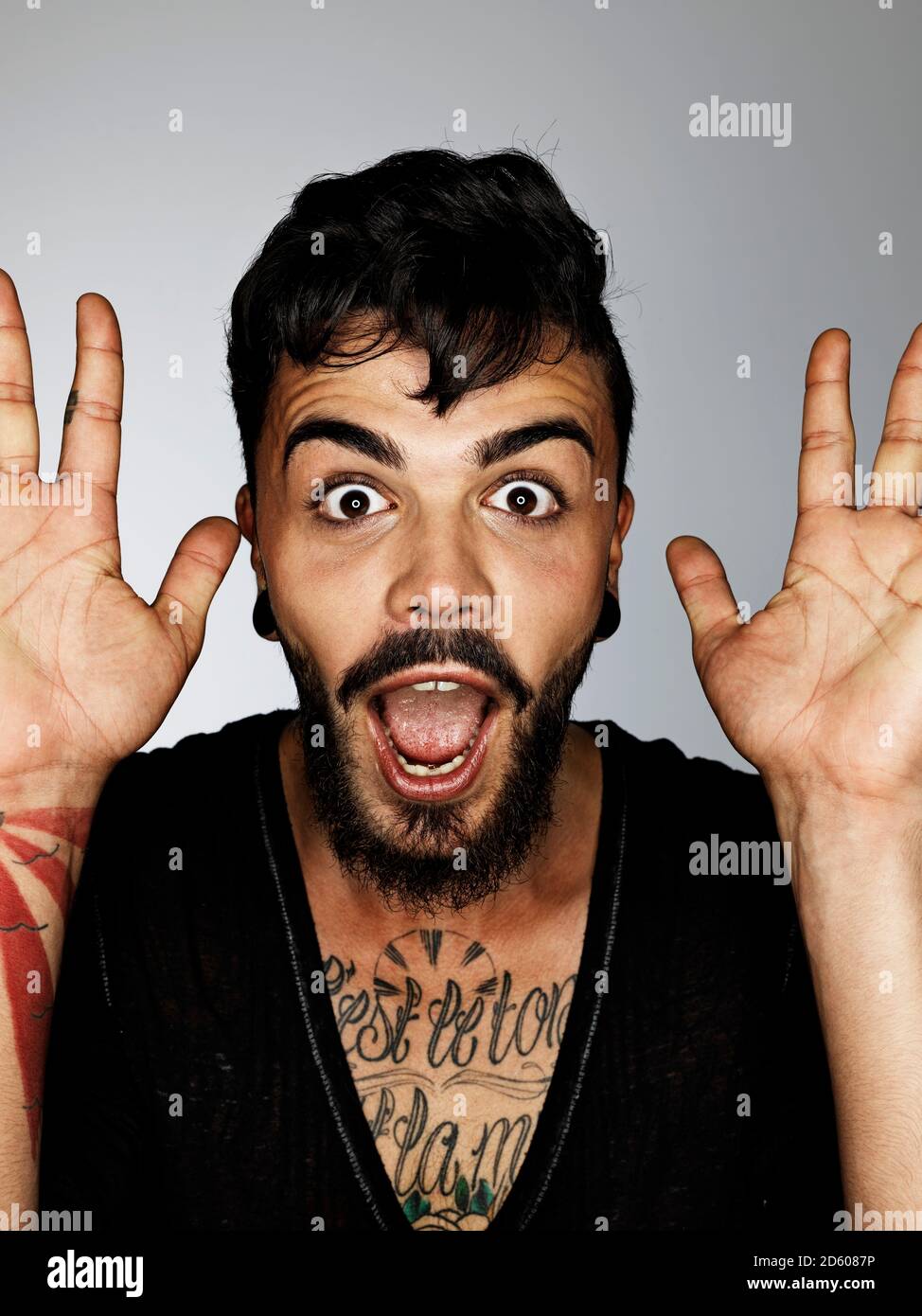 Ritratto di stupito uomo con tatuaggio sul suo petto Foto Stock