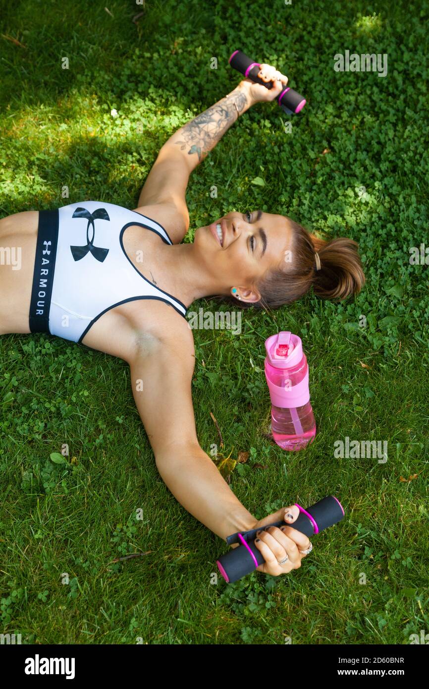Giovane donna sana in cima raccolto sportivo sdraiato la schiena Foto Stock