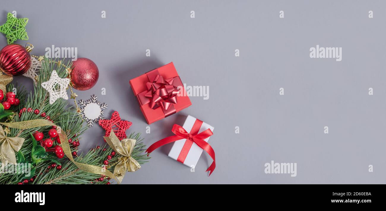 Sfondo banner. Composizioni natalizie e natalizie con regali su sfondo grigio laconico con spazio per la copia Foto Stock