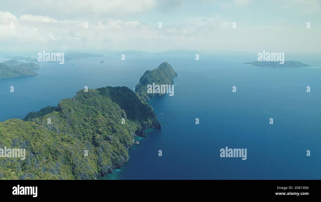 Vista aerea dell'isola tropicale dell'altopiano sulla baia blu dell'oceano. Isola montagnosa dell'Asia con paesaggio esotico di varietà della natura. Scenario estivo cinematografico dell'isolotto di Palawan, Filippine. Scatto morbido e leggero con drone Foto Stock