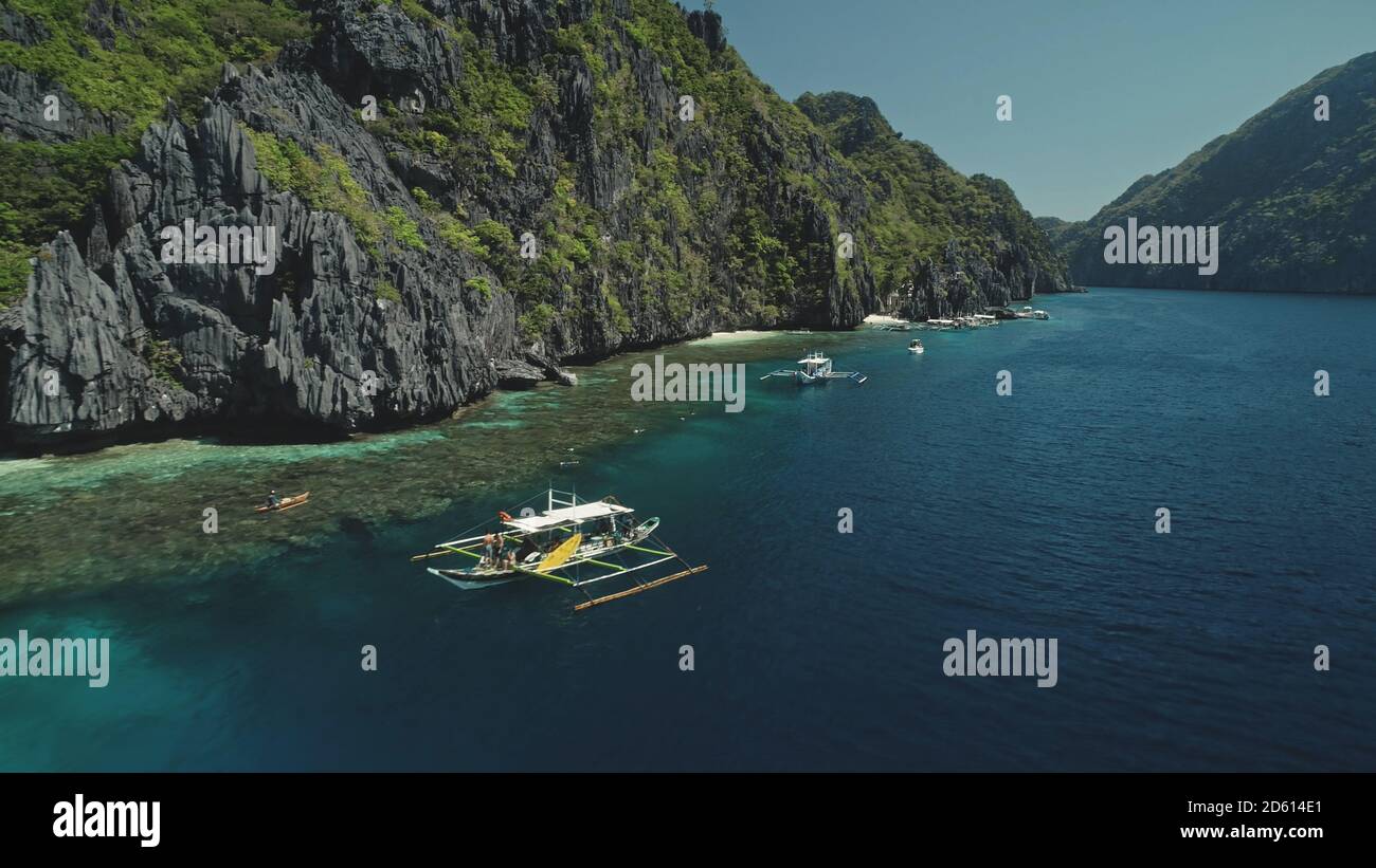 Navi vicino alla baia del mare con i passeggeri a crociera del paradiso estivo. Incredibile mare esotico e la natura in Asia a isola collina di El Nido, Filippine, arcipelago di Visayas. Riprese cinematografiche con luce soffusa Foto Stock