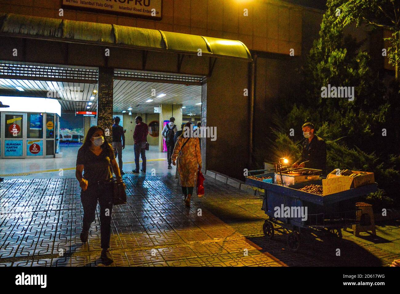 Ankara, Turchia. 14 ottobre 2020. Una donna che indossa una maschera protettiva passa davanti a un venditore di strada fuori da una stazione della metropolitana in mezzo all'epidemia di coronavirus (COVID-19). Credit: Altan Gocher/ZUMA Wire/Alamy Live News Foto Stock