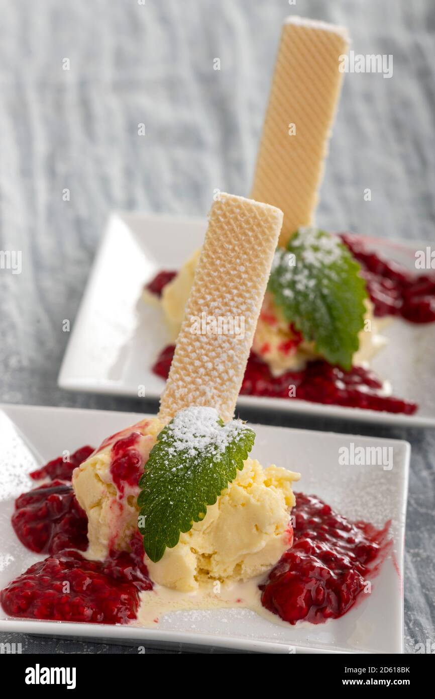 gelato alla vaniglia con salsa di lamponi calda Foto stock - Alamy