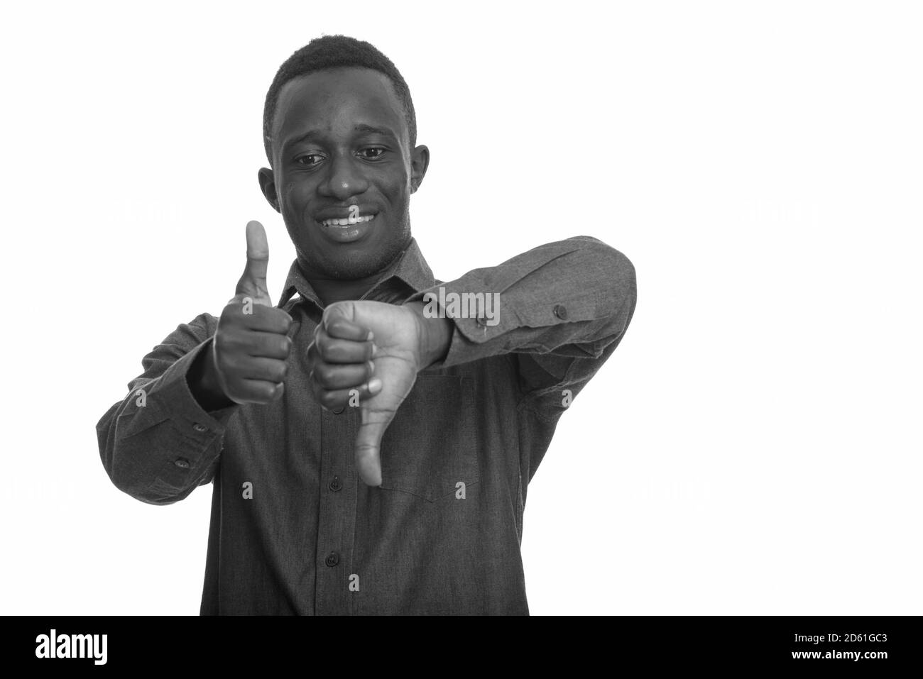 I giovani africani felice uomo sorridente mentre dando i pollici in su e in giù Foto Stock