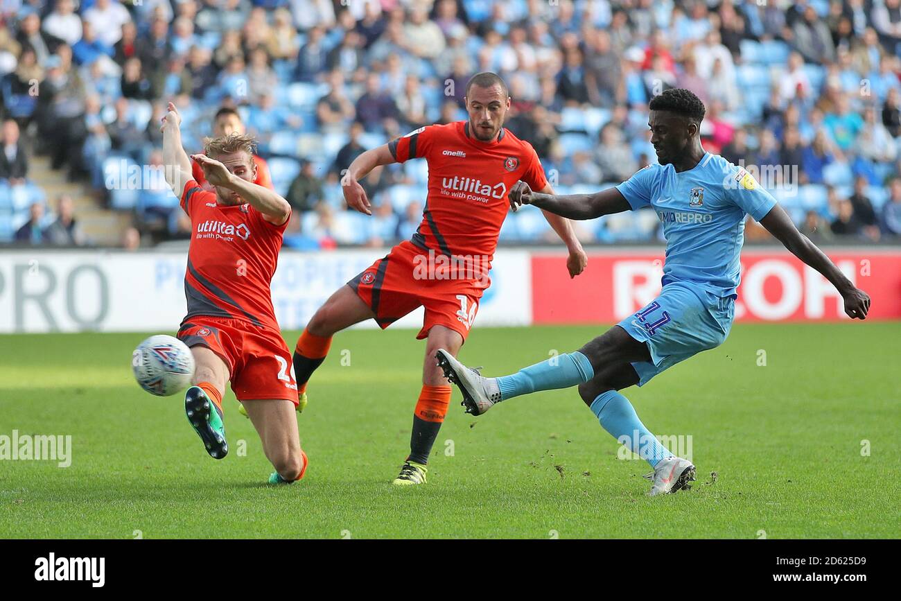 Jordy Hiwula di Coventry City (a destra) ha un colpo sul gol, sotto la pressione di Jason McCarthy di Wycombe Wanderers (a sinistra) e Michael Harriman Foto Stock