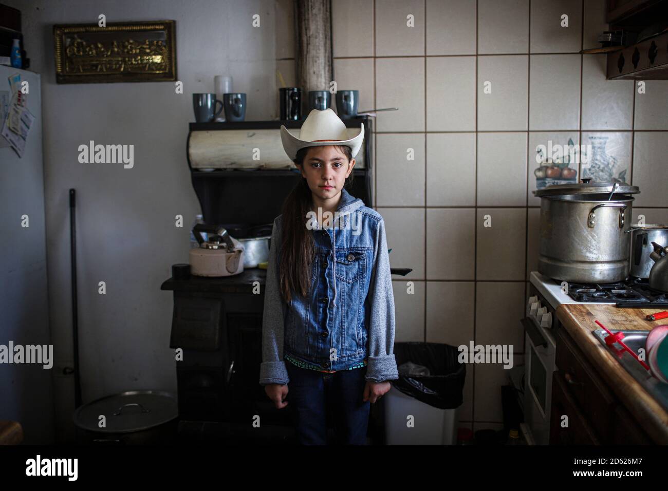 Ritratto della ragazza di 10 anni Cristina Burboa che indossa un cappello da cowboy nella cucina di sua nonna Domitila Burbua il 9 ottobre 2020 nella città di Frontera, Messico. Fronteras, sonora. Cowgirl, faccia, sguardo, jeans nel suono. (Foto di Luis Gutierrez / Norte Photo) Retrato de la niña Cristina Burboa de 10 años que viste de sombrero vaquero en la cocina de su abuela Domitila Burbua el 9 octubre 2020 en el pueblo de Fronteras, Messico. Fronteras, sonora. Aquera, rostro, mirada, vaqueros e sonora. (Foto di Luis Gutierrez/Norte Photo) Foto Stock