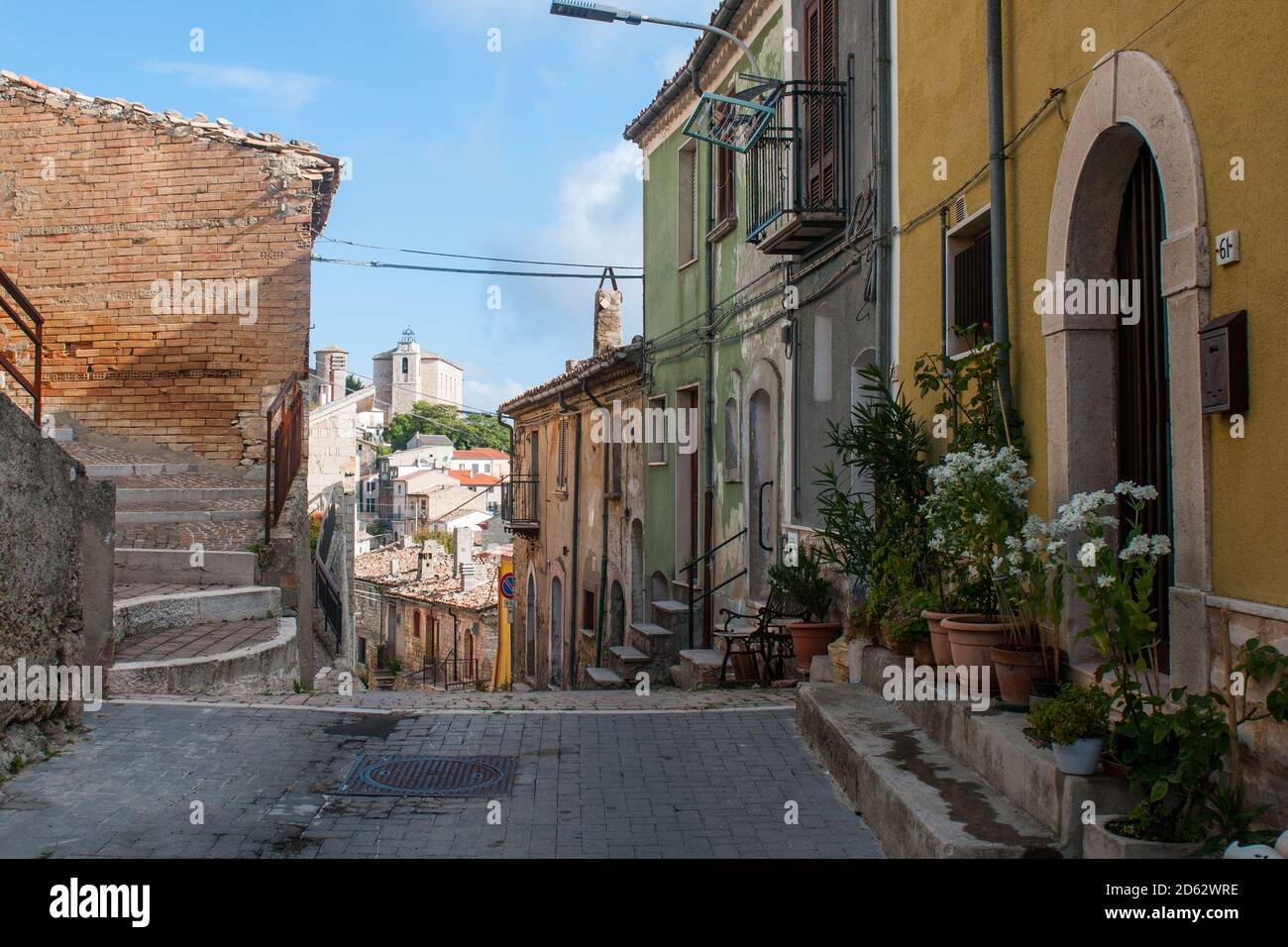 Una strada tipica del paese italiano Torrella del Sannio in Molise, con alcune pentole di fiori bianchi sul marciapiede Foto Stock