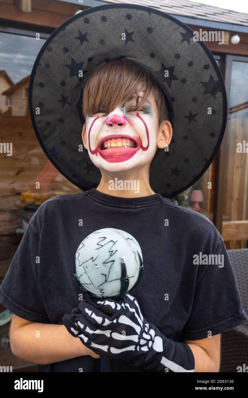 Make up clown ragazzo attore con cappello e costume di carnevale, clown pazzo, Halloween, carnevale facepaint come clown, espressioni pantomimiche Foto Stock
