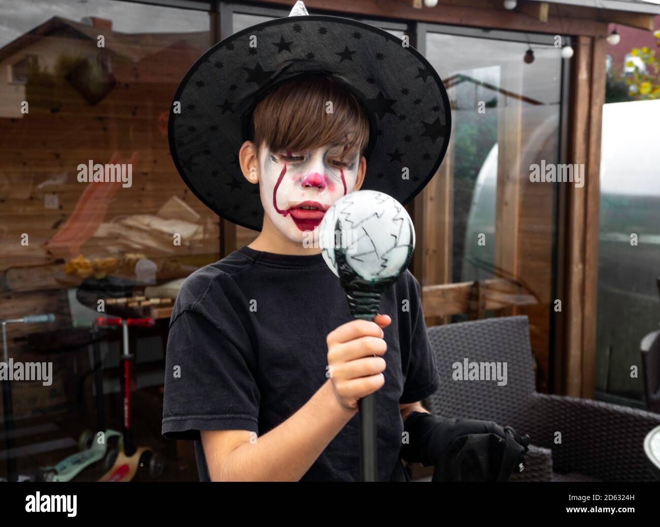 Make up clown ragazzo attore con cappello e costume di carnevale, clown pazzo, Halloween, carnevale facepaint come clown, espressioni pantomimiche Foto Stock