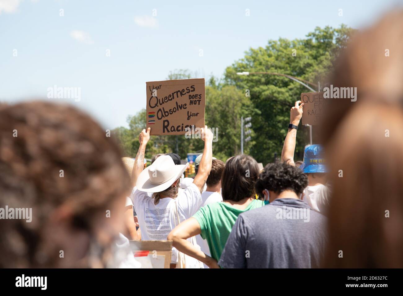 Il manifestante che tiene in mano la tua Querness non assolve il tuo segno del razzismo durante la protesta, Brooklyn, New York, USA Foto Stock