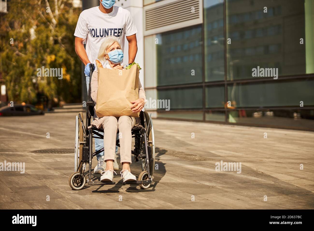 Una vecchia signora infelice che tornava dallo shopping Foto Stock