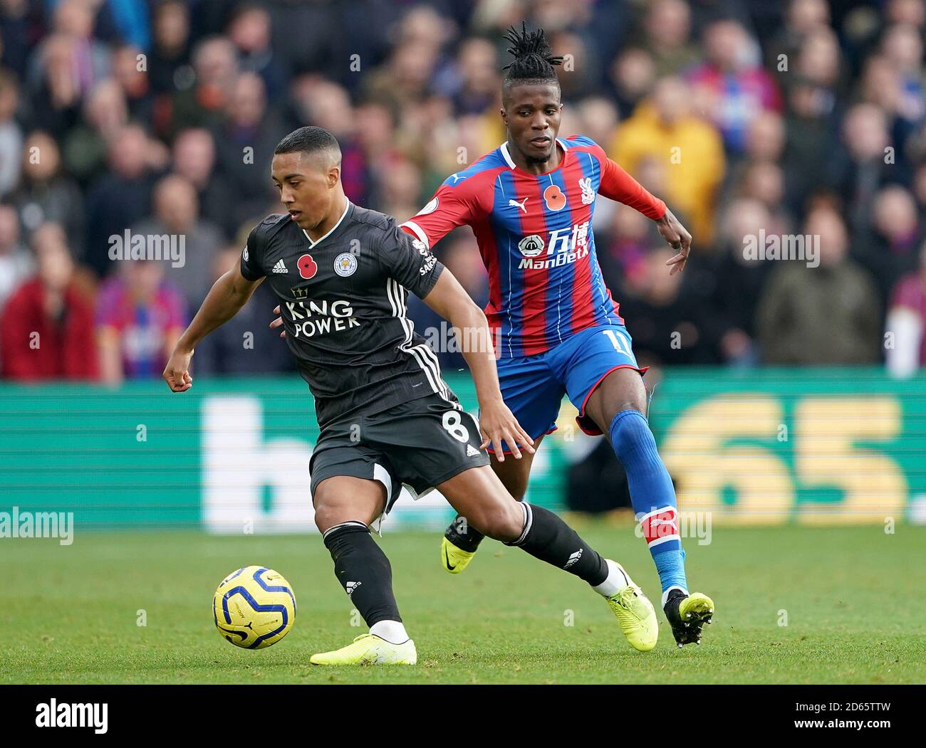 Youri Tielemans di Leicester City (a sinistra) e Wilfried Zaha di Crystal Palace si scontrano per la palla Foto Stock