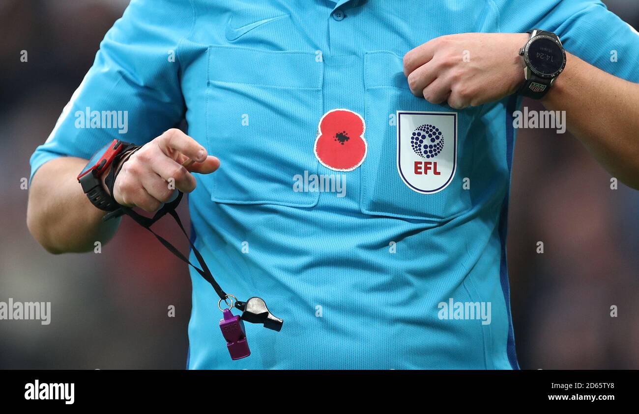 Un papavero del giorno della memoria sulla camicia dell'arbitro Foto Stock