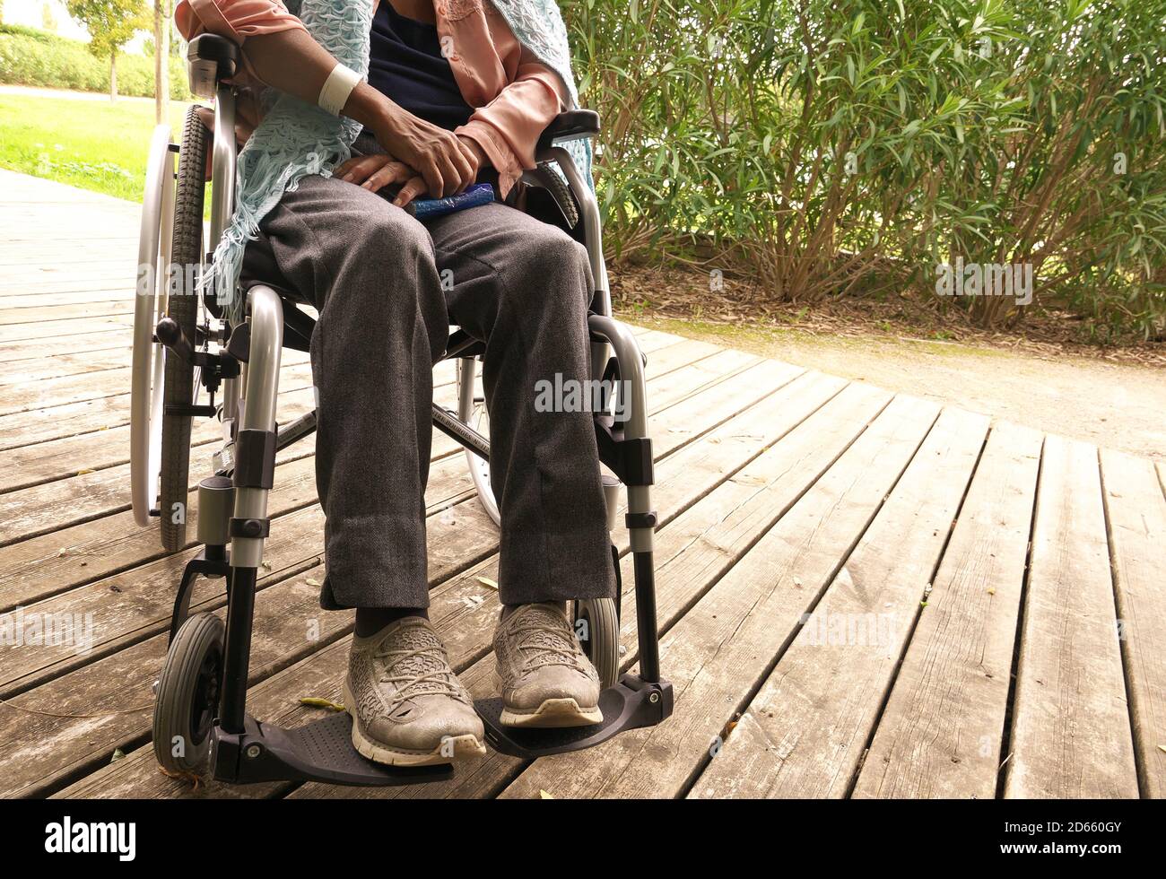 Primo piano delle gambe di una donna disabile in sedia a rotelle. Foto Stock