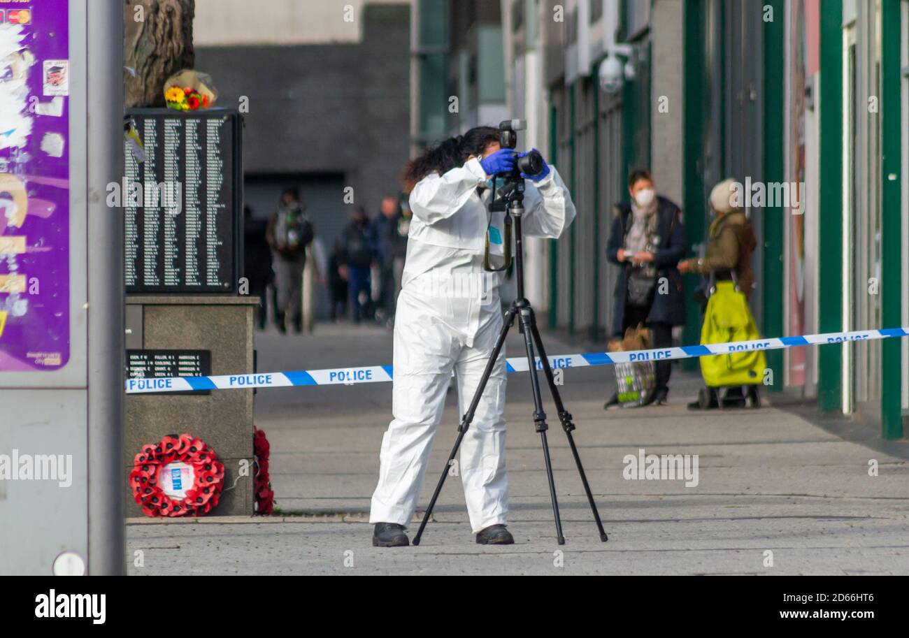 Un ufficiale forense femminile scatta foto sulla scena di un grave assalto notturno nel centro di Birmingham, vicino ai mercati all'aperto e all'arena Foto Stock