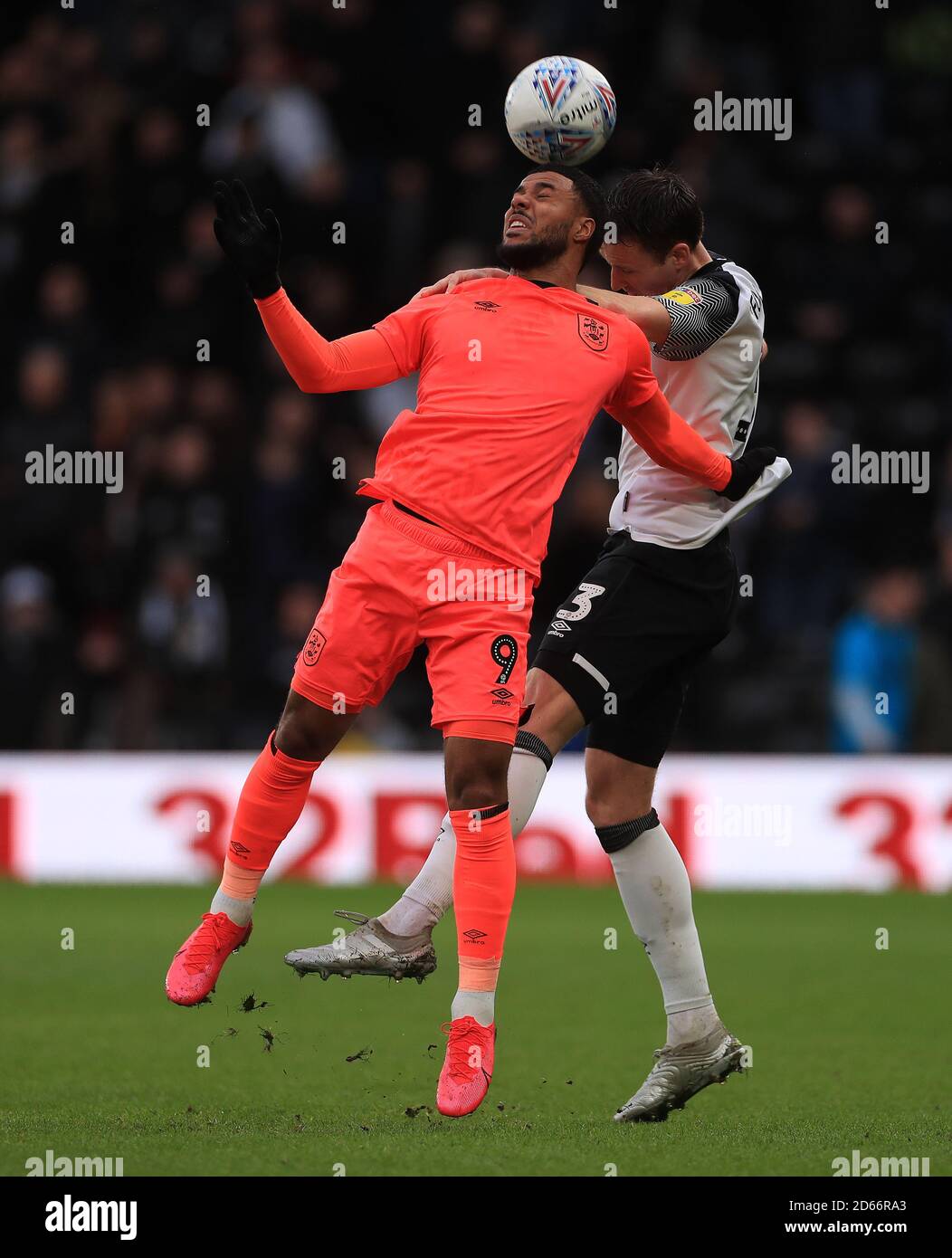 Craig Forsyth della Derby County e Elias Kachunga (a sinistra) della città di Huddersfield combattono per la palla Foto Stock