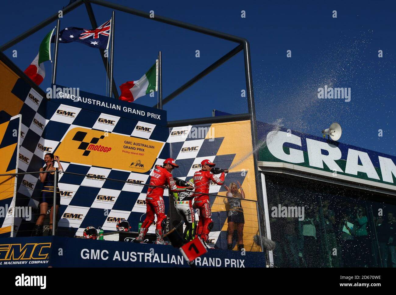 Casey Stoner (AUS) di Ducati Marlboro celebra il suo australiano Moto Grand Vittoria del premio con il compagno di squadra Loris Capirossi (ITA) e Fiat Yamaha Pilota Valentino Rossi (ITA) Foto Stock