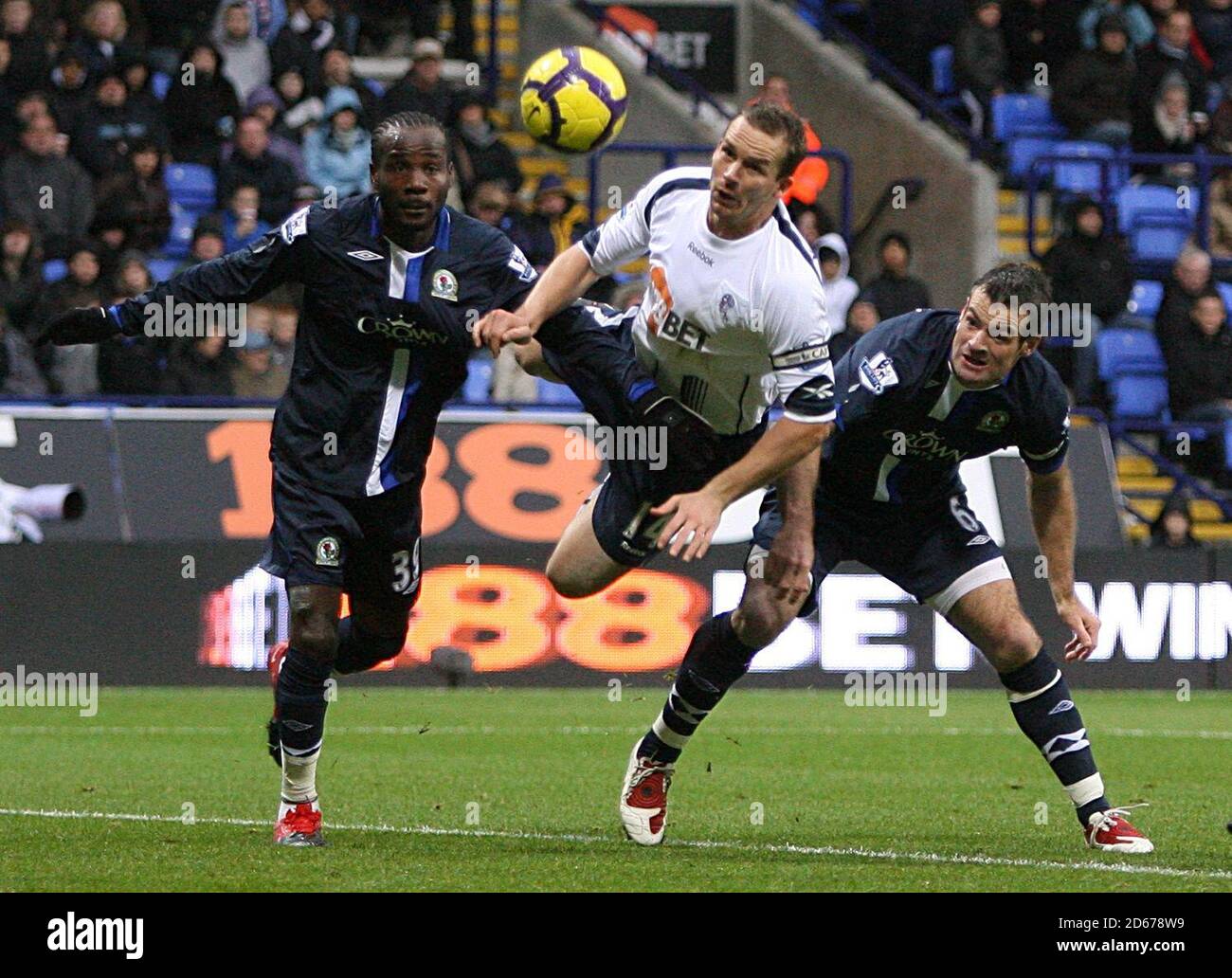 Kevin Davies di Bolton Wanderers (centro) combatte per la palla con Blackburn Rovers' Ryan Nelsen (a destra) e Pascal Chimbonda (a sinistra) Foto Stock