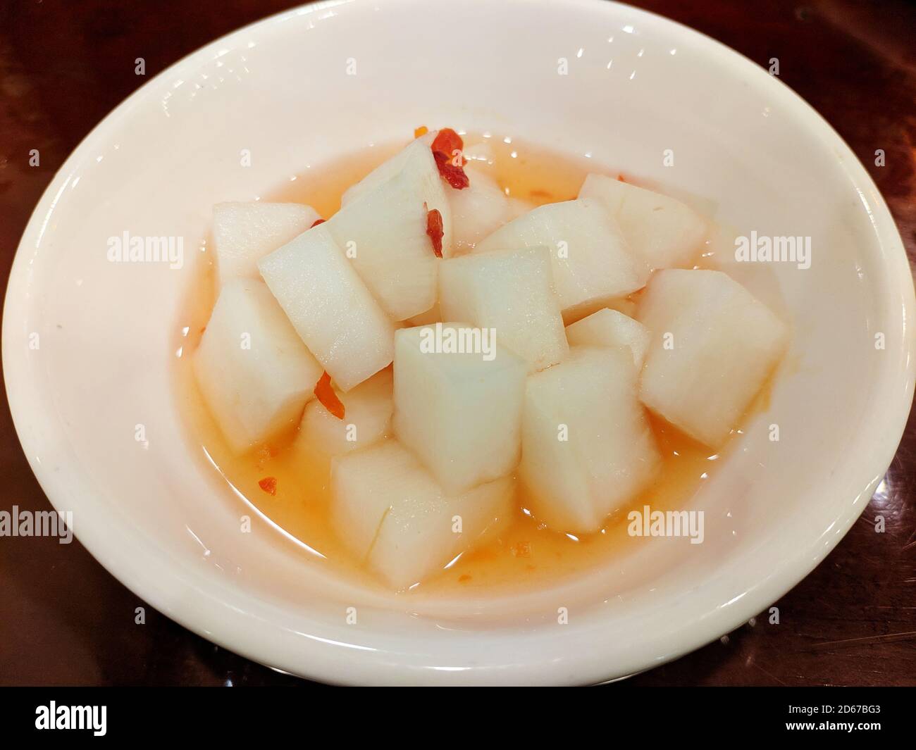 piatto bianco sottaceto e salato nella zuppa piccante in il recipiente bianco Foto Stock