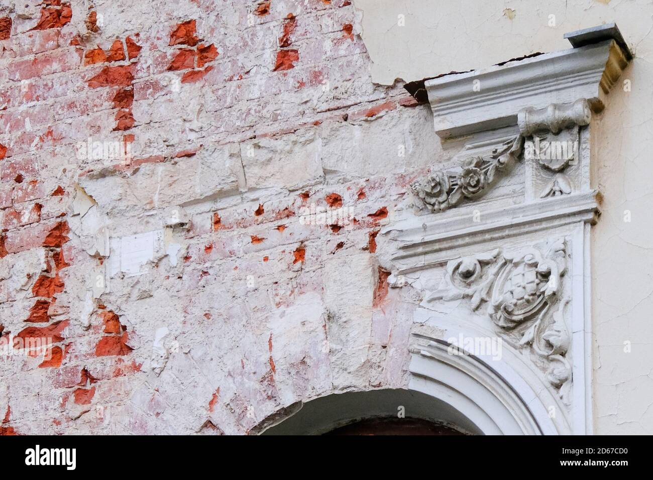 Frammento di facciata con stucco rovinato di un vecchio edificio abbandonato. Foto Stock