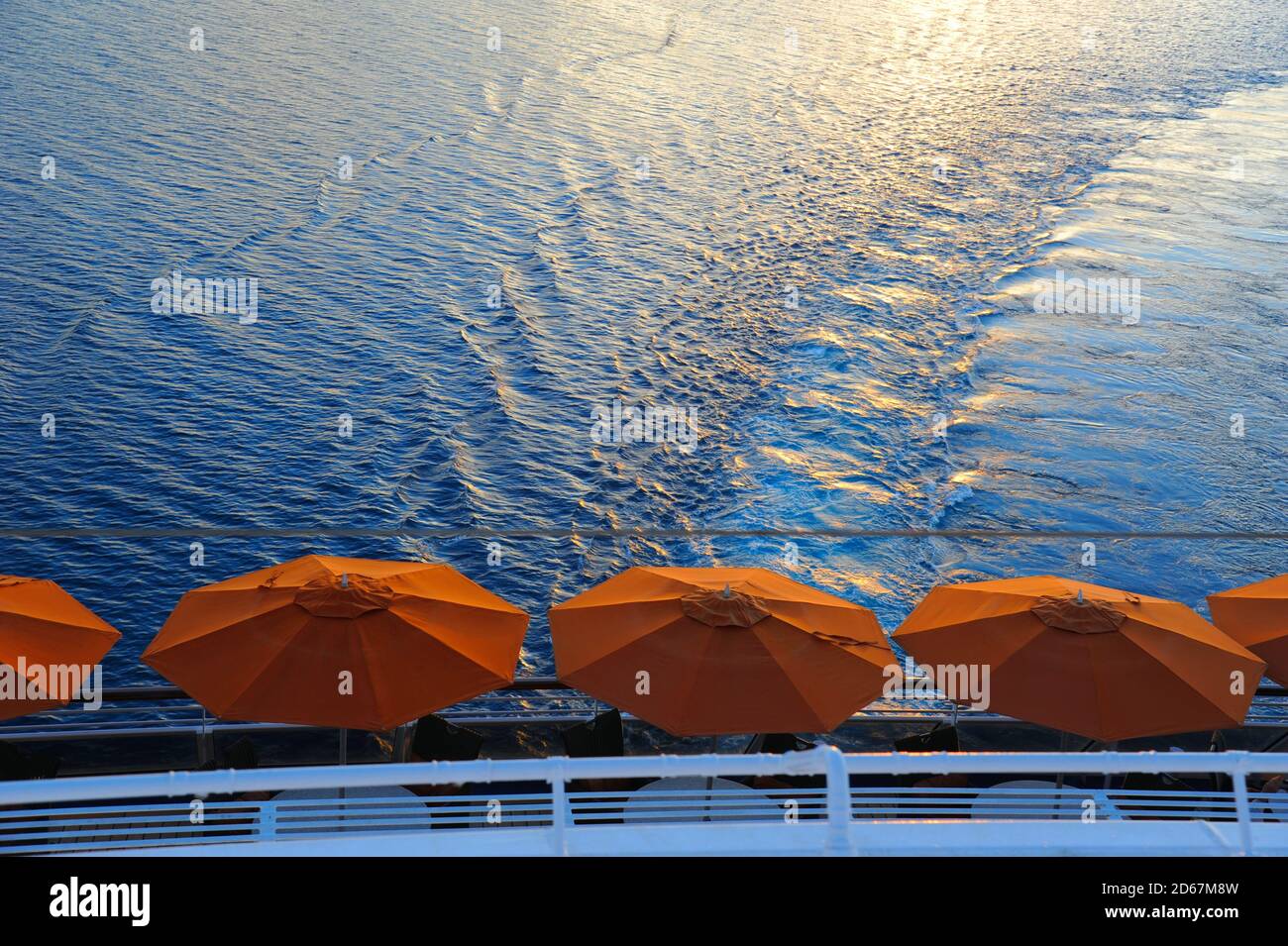 Ombrello arancione sul retro di una nave da crociera che naviga intorno alle isole Polinesiane. Foto Stock