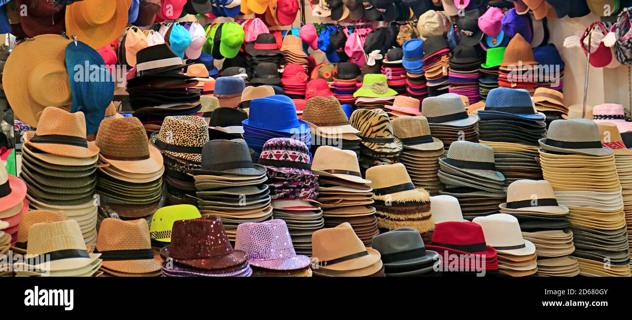 Pile di cappelli alla moda in stili e colori diversi in il negozio di cappelli Foto Stock