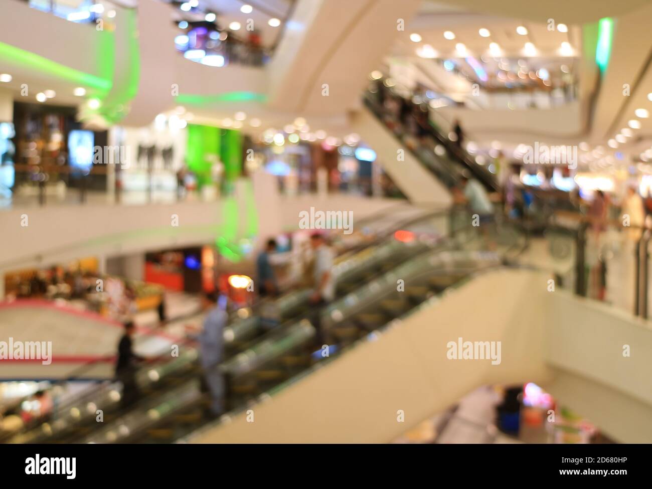 Astratto centro commerciale offuscato con persone sulle scale mobili Foto Stock