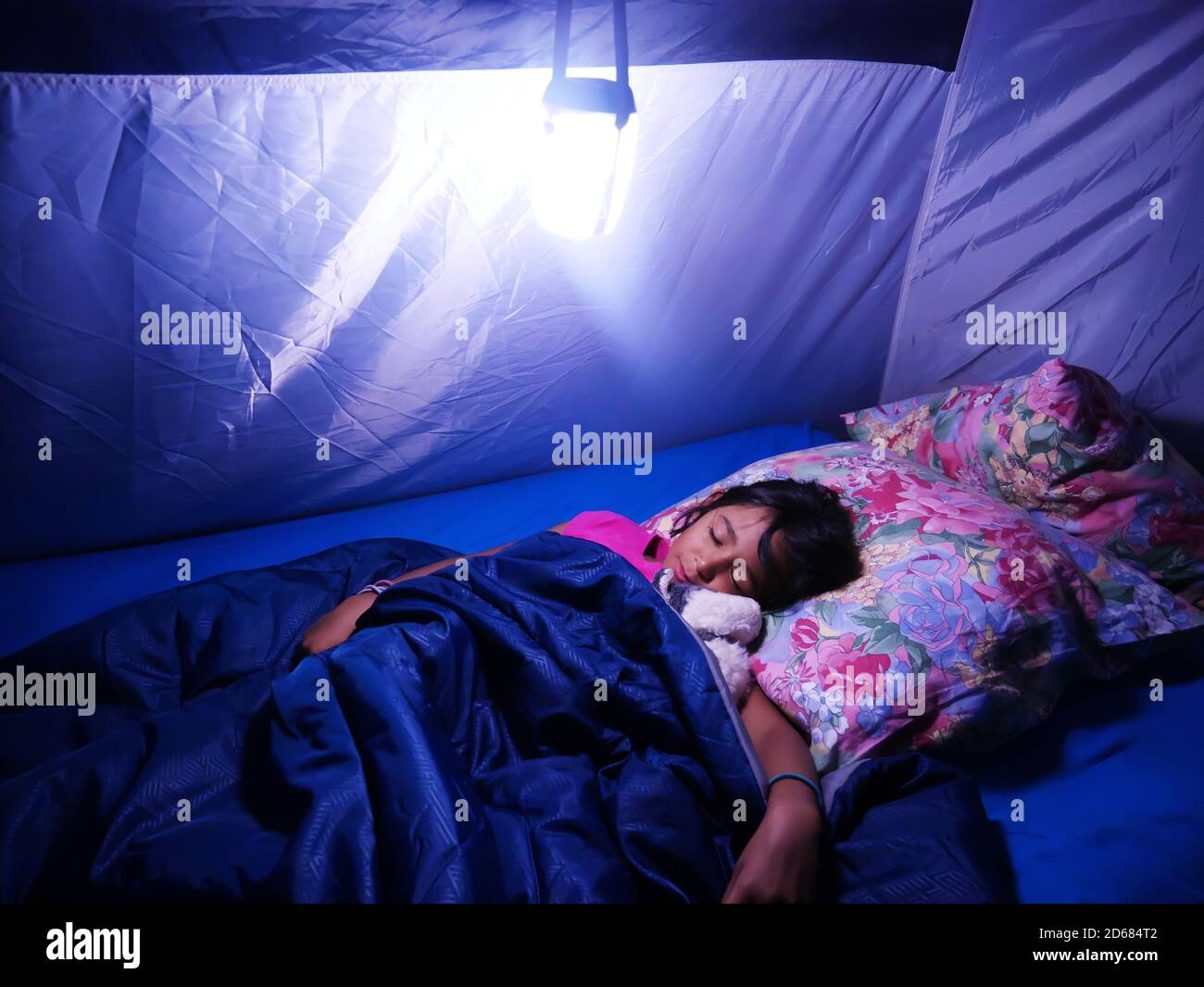 Piccola ragazza Metis che dorme sonoramente in una tenda da campeggio durante le vacanze. Foto Stock