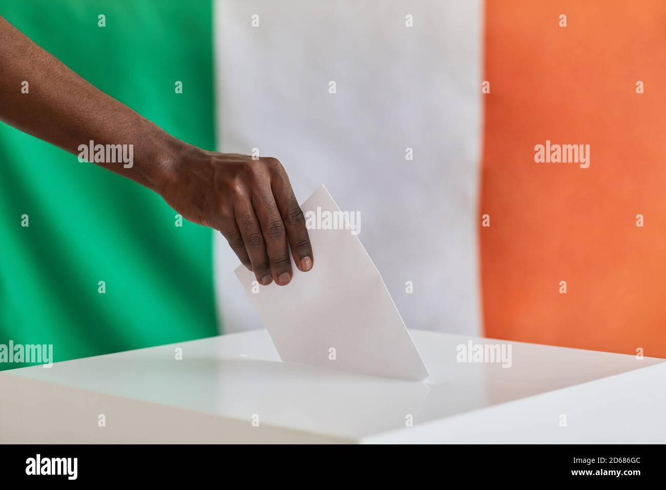 Primo piano di un uomo africano che mette la busta nella scatola alla stazione di polling Foto Stock