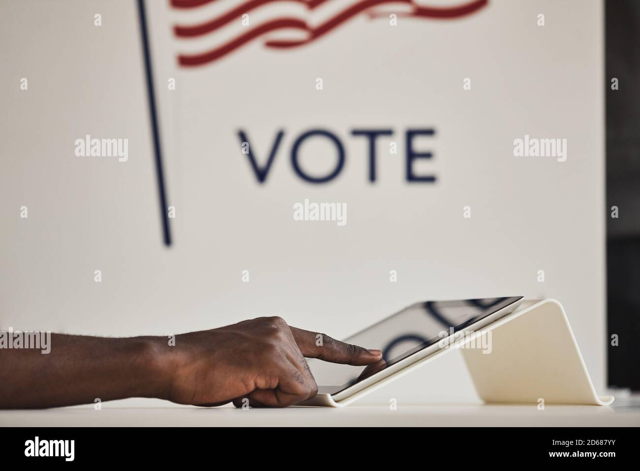 Primo piano di un uomo africano che tocca lo schermo del computer durante la votazione nella stazione di polling Foto Stock