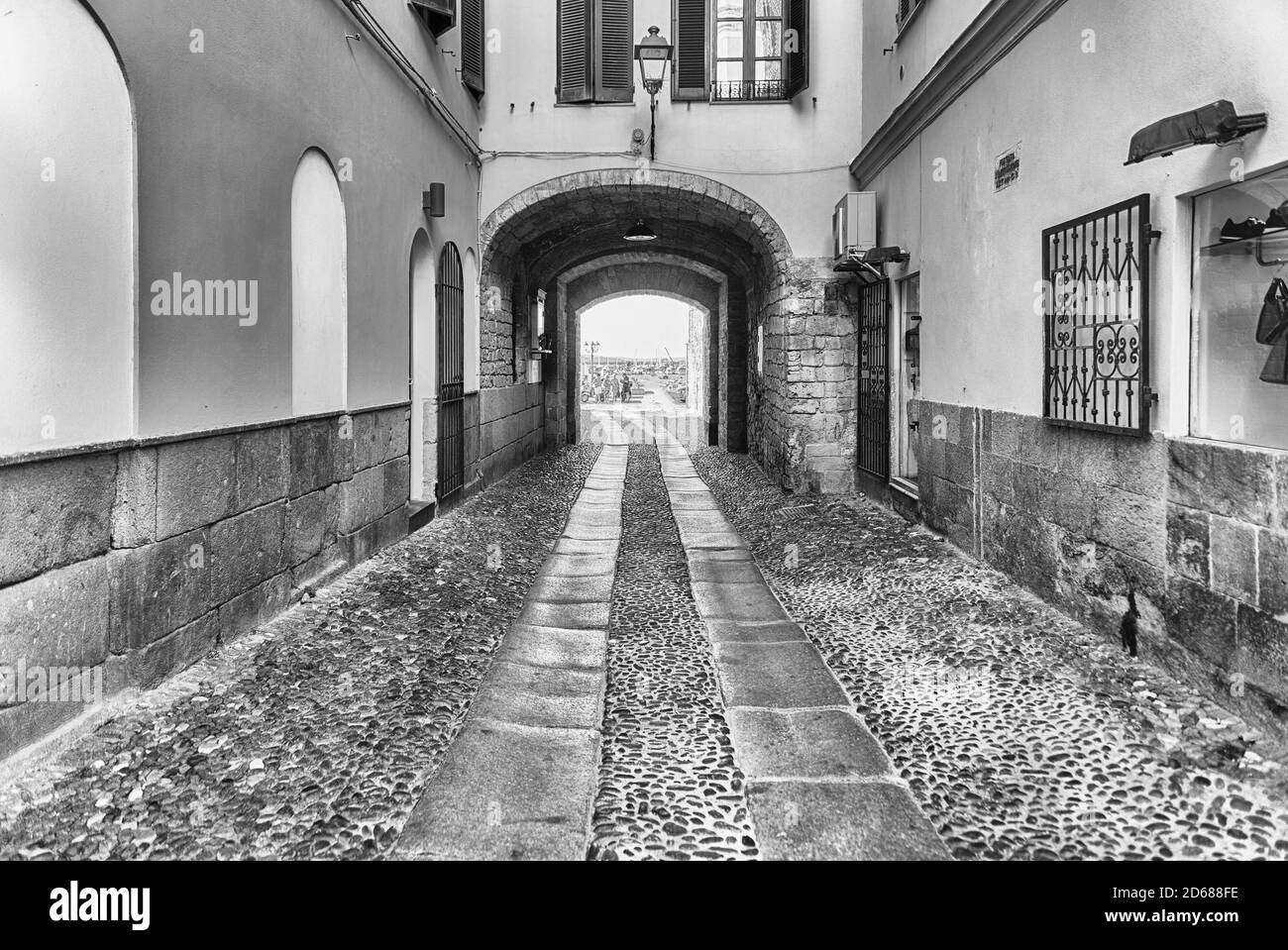 Passeggiate nelle pittoresche strade acciottolate di Alghero, famoso centro e località turistica nella Sardegna nord-occidentale, Italia Foto Stock