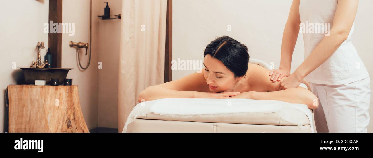 Bella donna che riceve un massaggio alla schiena. Bella donna mista di razza si rilassa mentre massaggiando il suo corpo. Foto Stock