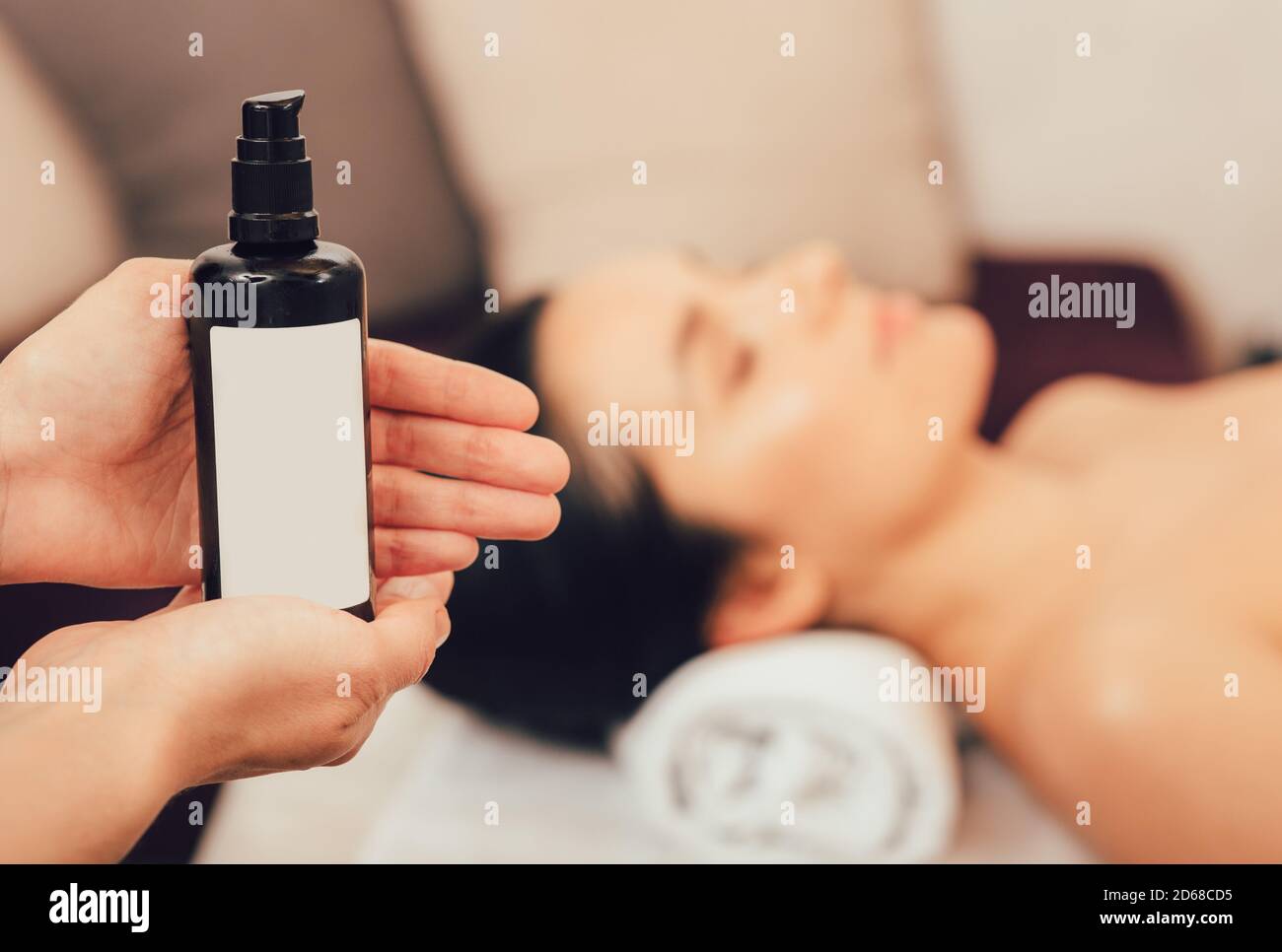 Massaggio ayurvedico con oli aromatici. Massaggio corpo thailandese, relax aromatico. Olio da massaggio primo piano, bella donna con messa a fuoco morbida Foto Stock