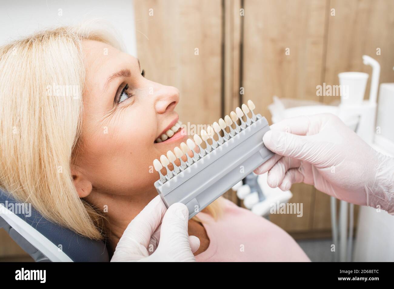 Tavolozza dei denti con diverse sfumature di denti vicino alle donne sorridenti. Stomatologia, sbiancamento dei denti, impianto dentario, veneer, corone e dentellature Foto Stock