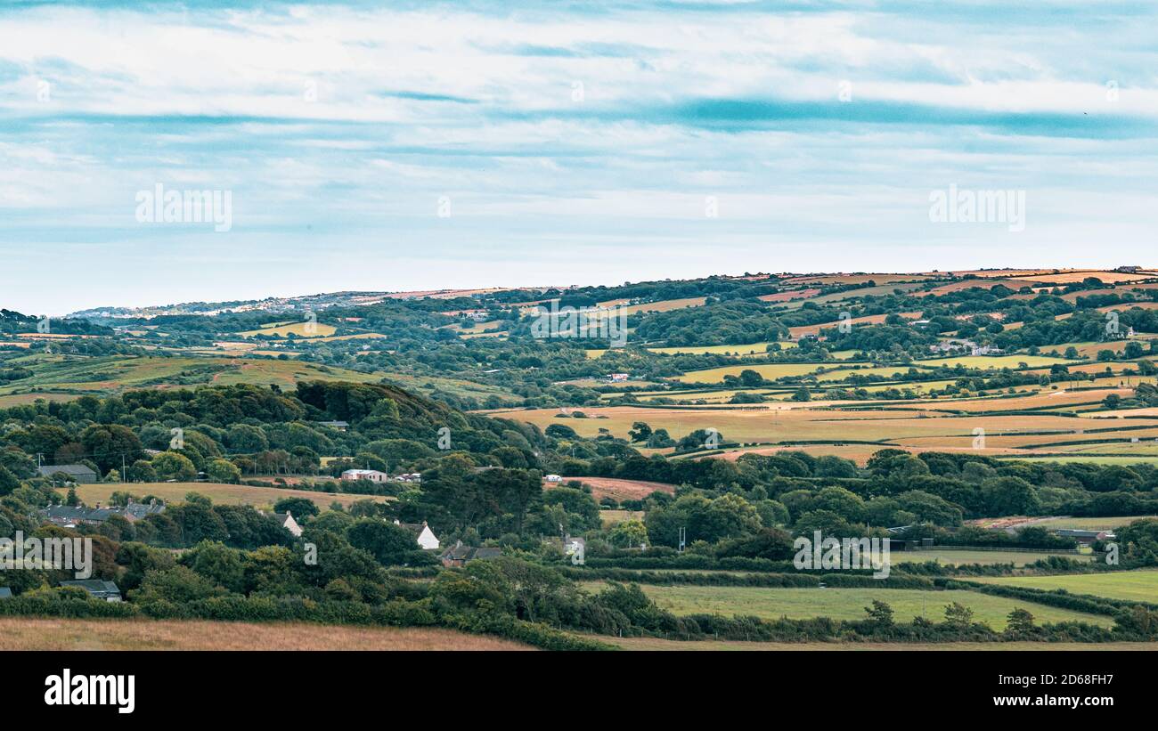 Splendido punto di riferimento delle fattorie del Devonshire, vista a distanza per alberi e campi, per lo più paesaggio artificiale di fattorie britanniche e campi da pascolo per Foto Stock