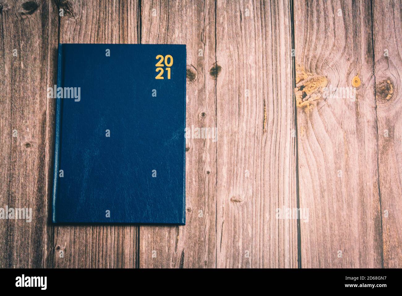 un diario blu 2021 posto su una scrivania rustica in legno Foto Stock