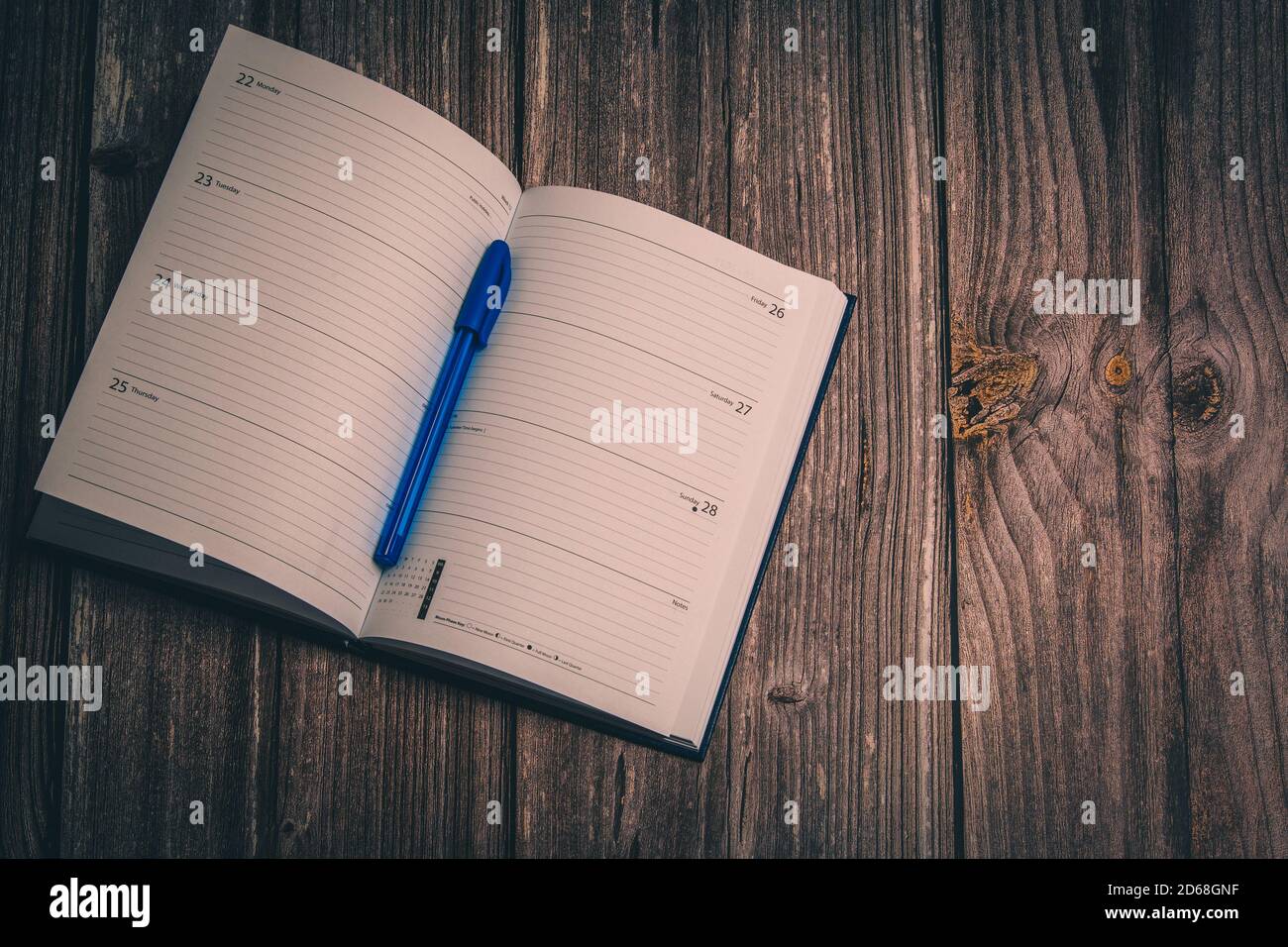 Un diario aperto con una penna posata su un rustico scrivania in legno Foto Stock