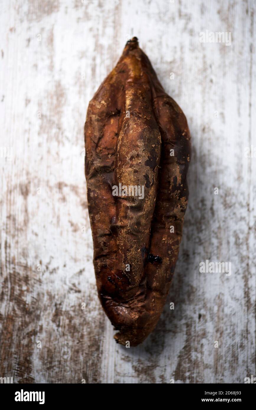 vista ad alto angolo di una patata dolce arrostita su un rustica superficie in legno bianco Foto Stock
