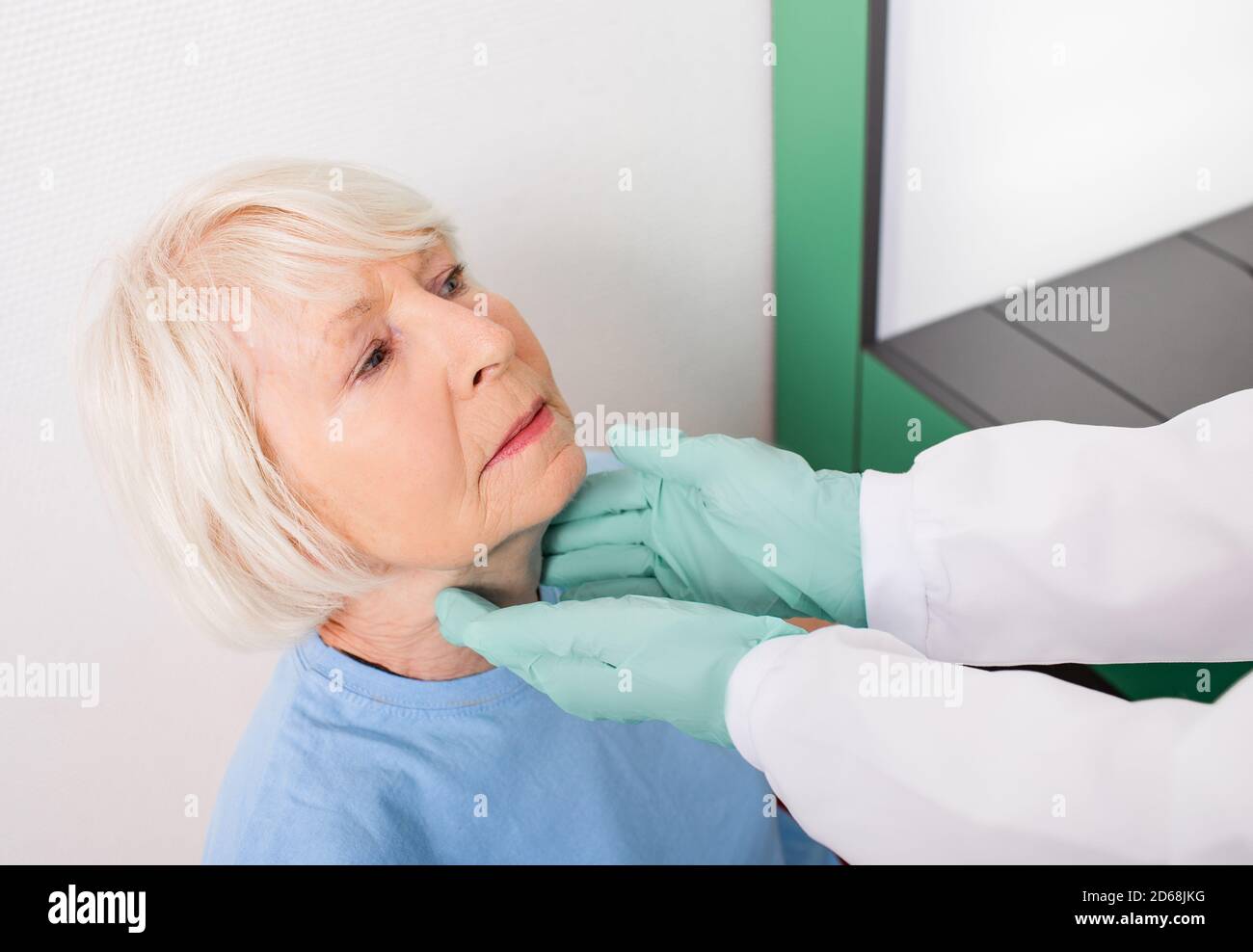 Una donna anziana ha un controllo della tiroide. Diagnosi di malattie del sistema endocrino, ipertiroidismo e ipotiroidismo Foto Stock