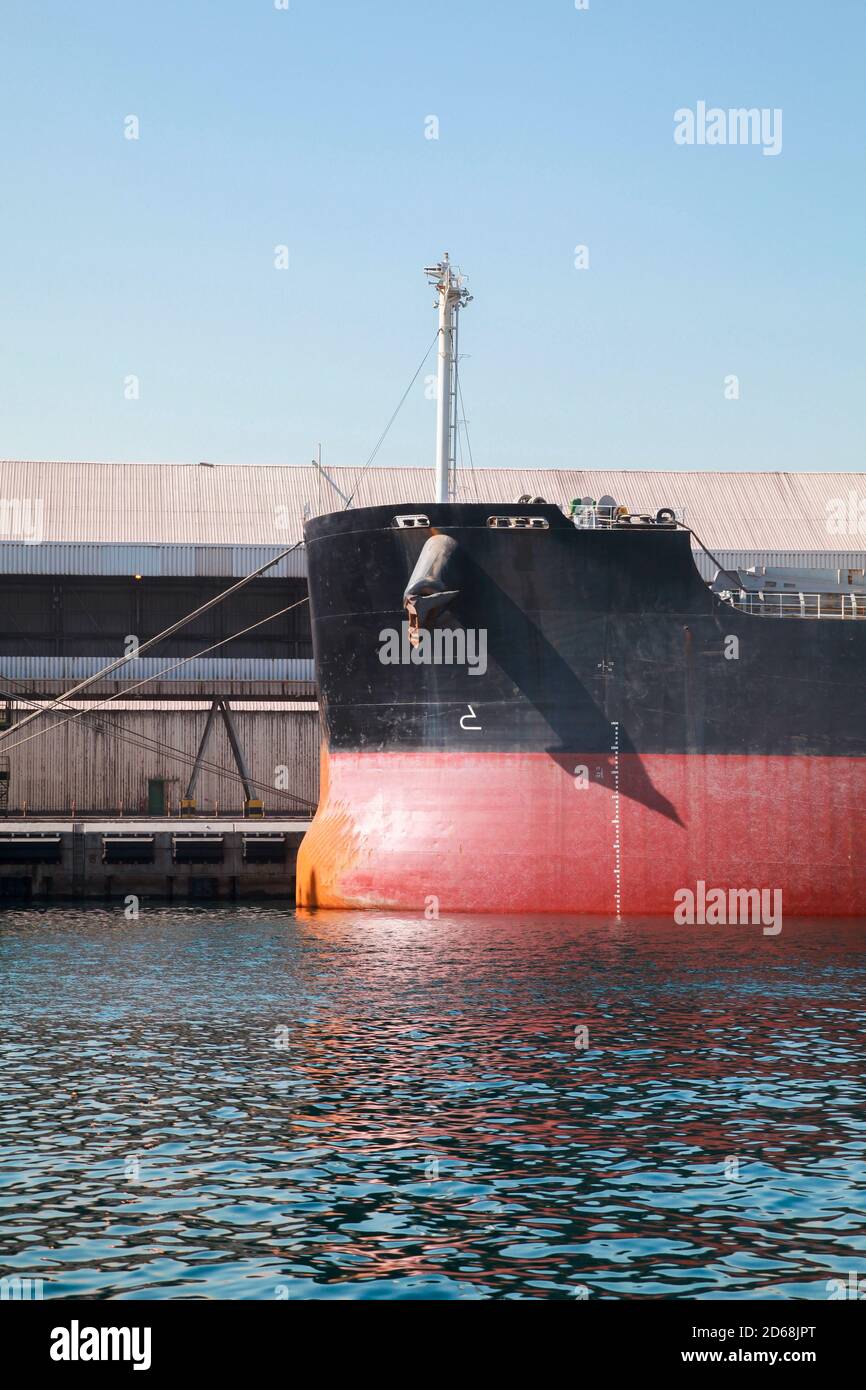 Prua di una nave da carico con ormeggiata in un porto. Foto trasporto industriale verticale Foto Stock